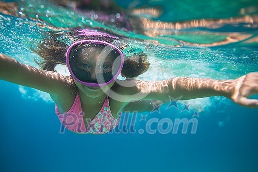 LIttle girl swimming underwater in the sea, enjoying summer fully LIttle girl swimming underwater in the sea, enjoying summer fully