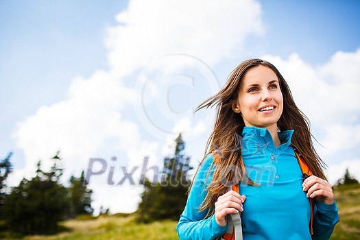 Pretty, young woman hiking outdoors in splendid alpine setting