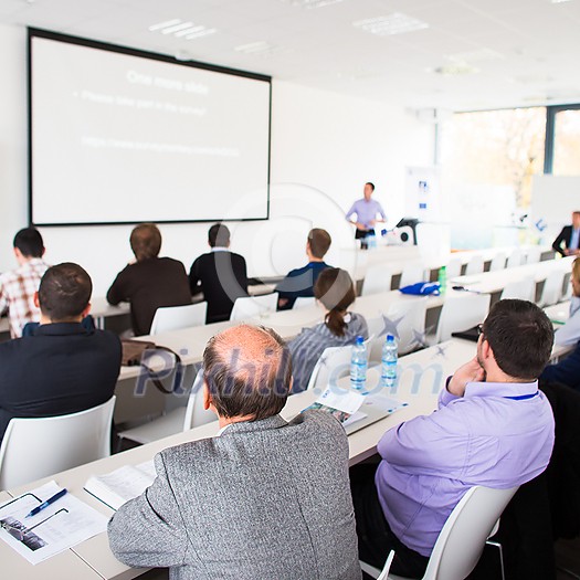 People in a conference room listening to a speech People in a conference room listening to a speech