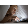 Pretty young woman using a tablet computer in bed