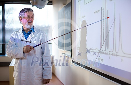 Senior chemistry professor giving a lecture in front of classroom full of students (shallow DOF; color toned image) Senior chemistry professor giving a lecture in front of classroom full of students (shallow DOF; color toned image)