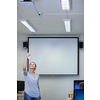 Pretty, young female teacher in a classroom, gettring ready to teach a class, preparing a projector
