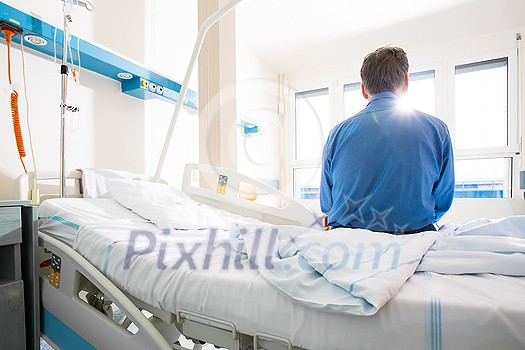 Senior male patient in a modern hospital. Getting better after a surgery/illness (shallow DOF; color toned image)