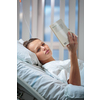 Pretty, young, female patient in a modern hospital room. Reeding a book (shallow DOF; color toned image)