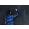 Smart  Arab Teen Boy with chalk in hand writing on empty black board in school