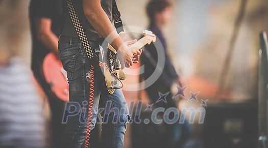 Band performing live on a stage, in front of huge crowd Band performing live on a stage, in front of huge crowd