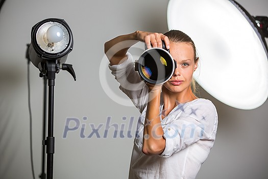Pretty, female photographer with digital camera - DSLR and a huge telephoto lens (color toned image; shallow DOF) Pretty, female photographer with digital camera - DSLR and a huge telephoto lens (color toned image; shallow DOF)