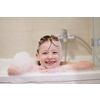 little girl playing with soap foam in bath during coronavirus stay at home pandemic quarantine