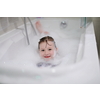 little girl playing with soap foam in bath during coronavirus stay at home pandemic quarantine