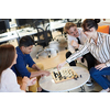 multiethnic group of business people playing chess while having a break in relaxation area at modern startup office