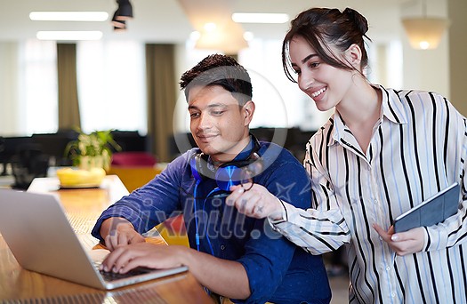multiethnic business people Indian man with a female colleague working together on tablet and laptop computer in relaxation area of modern startup office