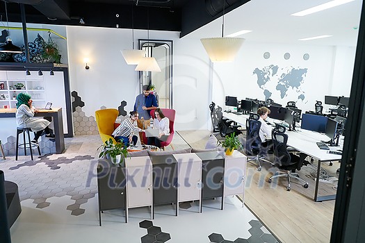 group of casual multiethnic business people taking break from the work doing different things while enjoying free time in relaxation area at modern open plan startup office