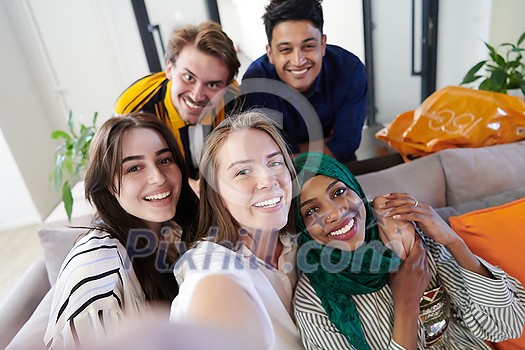 group of casual multiethnic business people during break from the work taking selfie picture while enjoying free time in relaxation area at modern open plan startup office