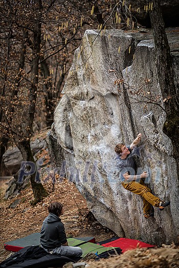 Rock climbers climbing on a boulder rock outdoors Rock climbers climbing on a boulder rock outdoors