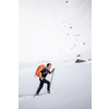 Winter sports - young man walking with snowshoes in high mountains covered with lots of snow (selective focus on the mountain in the background)