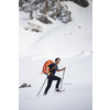 Winter sports - young man walking with snowshoes in high mountains covered with lots of snow (selective focus on the mountain in the background)