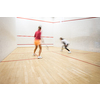 Two female squash players in action on a squash court (motion blurred image; color toned image)