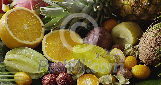 Pouring water on a fresh organic natural exotic fruits. Close-up video. Panoramic motion, 4K UHD video, 3840, 2160p. Concept of vegetarian diet eating.