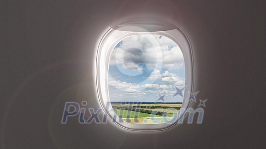 Panoramic aerial video of rural landscape with agricultural lands and fields on a background of cloudy blue sky from porthole inside airplane. 4K UHD video 3840, 2160p. Panoramic aerial video of rural landscape with agricultural lands and fields on a background of cloudy blue sky from porthole inside airplane. 4K UHD video 3840, 2160p.