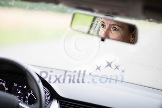 Pretty midle aged woman at the steering wheel of her car commuting to work Pretty midle aged woman at the steering wheel of her car commuting to work