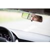 Pretty midle aged woman at the steering wheel of her car commuting to work