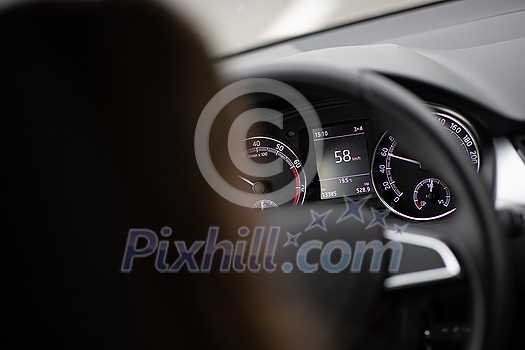 Pretty midle aged woman at the steering wheel of her car commuting to work Pretty midle aged woman at the steering wheel of her car commuting to work