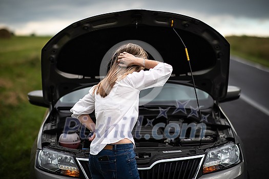 Pretty middle aged woman having car troubles - broken down car on the side of the road, calling the insurance company for assistance Pretty middle aged woman having car troubles - broken down car on the side of the road, calling the insurance company for assistance
