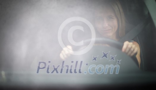 Pretty midle aged woman at the steering wheel of her car Pretty midle aged woman at the steering wheel of her car