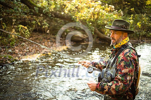 Fly fisherman fly fishing on a splendid mountain river Fly fisherman fly fishing on a splendid mountain river