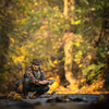 Close-up view of the hands of a fly fisherman holding a lovely trout while  fly fishing on a splendid mountain river