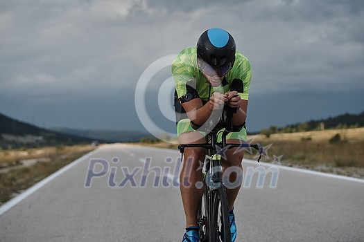 triathlon athlete riding professional racing bike at workout on curvy country road