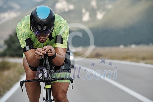 triathlon athlete riding professional racing bike at workout on curvy country road