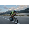 triathlon athlete riding professional racing bike at workout on curvy country road