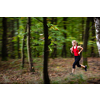 Pretty. young woman running fast in a forest - motion blur technique used to convey speed and movement