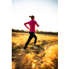 Young woman running outdoors on a lovely sunny winter/fall day (motion blurred image)