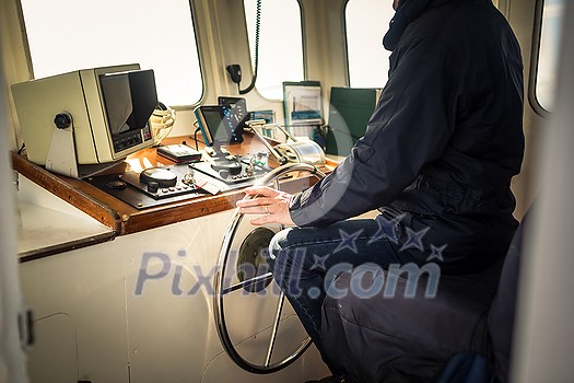 Boat or yacht captain hand on boat steering wheel and sea navigation system, close up Boat or yacht captain hand on boat steering wheel and sea navigation system, close up