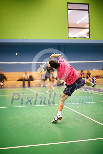 Male badminton player in the middle of a fast paced badminton rally Male badminton player in the middle of a fast paced badminton rally