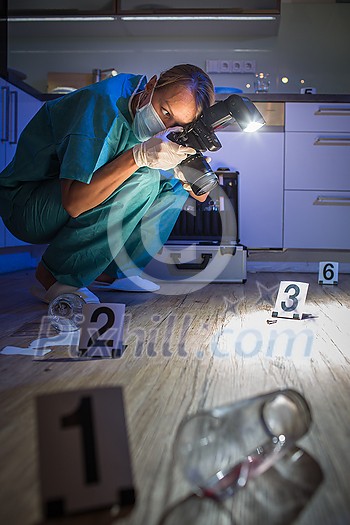 Forensic specialist in protective suit taking photos on a crime scene Forensic specialist in protective suit taking photos on a crime scene
