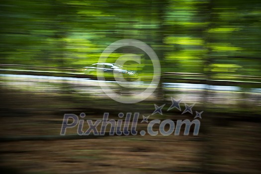 Cars going fast on an interstate road amid forests Cars going fast on an interstate road amid forests
