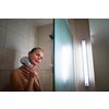 Young woman washing her hair with shampoo, taking a hot long shower