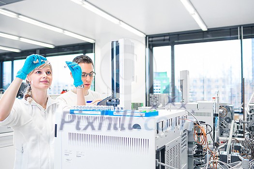 Two young researchers carrying out scientific research in a lab using a gas chromatograph (shallow DOF; color toned image) Two young researchers carrying out scientific research in a lab using a gas chromatograph (shallow DOF; color toned image)