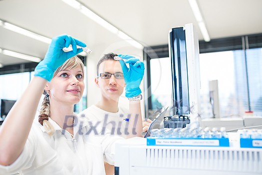 Two young researchers carrying out scientific research in a lab using a gas chromatograph (shallow DOF; color toned image) Two young researchers carrying out scientific research in a lab using a gas chromatograph (shallow DOF; color toned image)
