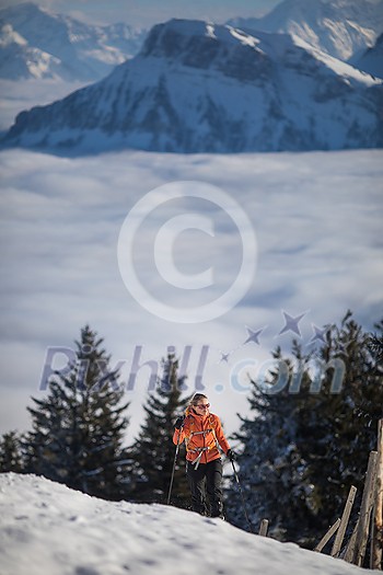 Young woman snowshoeing in high mountains, enjoying a lovely day