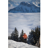 Young woman snowshoeing in high mountains, enjoying a lovely day