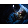 Pretty, middle-aged woman using her cell phone in bed at home before sleep