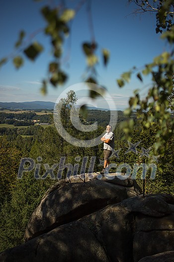 Senior man enjoying the outdoors, hiking, walking throught lovely nature