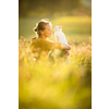 Pretty, young woman with her cat pet sitting in grass on lovely meadow lit by warm evening light (shallow DOF; color toned image)