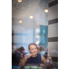 Pretty, young woman eating sushi in a restaurant, having her lunch break, enjoying the food, pausing for a while from her busy corporate/office life (color toned image)