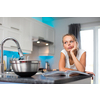 Pretty, young woman in her modern, clean and bright kitchen, fixing lunch (color toned imagey; shallow DOF)