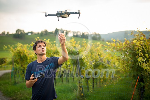 Young man flying a drone in warm evening sunlight Young man flying a drone in warm evening sunlight